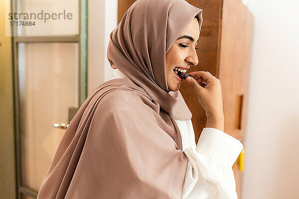 Junge muslimische Frau isst Dattel zum Fastenbrechen