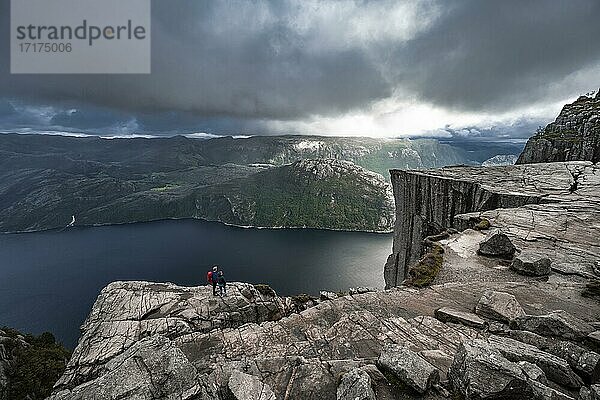Zwei (Wanderer) vor Felsplateau  Felskanzel Preikestolen  Lysefjord  Ryfylke  Rogaland  Norwegen  Europa