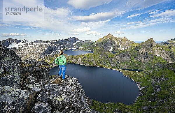 Junge Frau blickt über Berglandschaft mit See Tennesvatnet und Krokvatnet  Blick vom Gipfel des Munken  Moskenesöy  Lofoten  Nordland  Norwegen  Europa