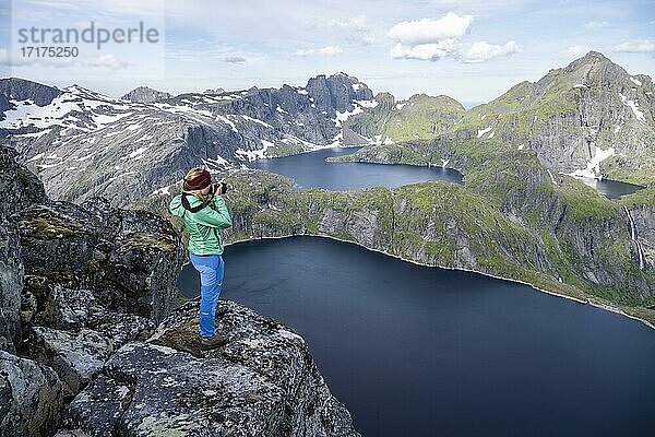 Junge Frau blickt über Berglandschaft mit See Tennesvatnet  Blick vom Gipfel des Munken  Moskenesöy  Lofoten  Nordland  Norwegen  Europa