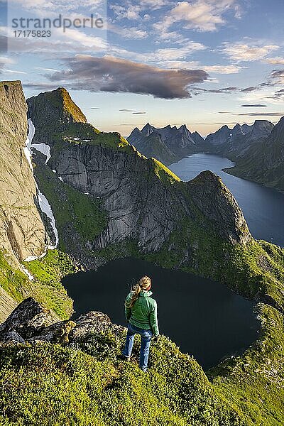 Junge Wanderin genießt Aussicht vom Reinebringen  Reinebriggen  Reinefjord mit Bergen  Moskenes  Moskenesöy  Lofoten  Norwegen  Europa