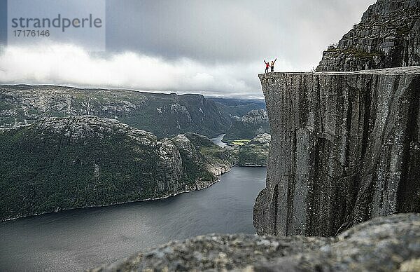 Zwei Menschen an Felsplateau  Felskanzel Preikestolen  Lysefjord  Ryfylke  Rogaland  Norwegen  Europa