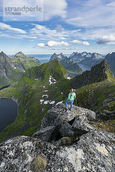 Junge Frau blickt über Berglandschaft mit See Tennesvatnet  Blick vom Gipfel des Munken  Moskenesöy  Lofoten  Nordland  Norwegen  Europa