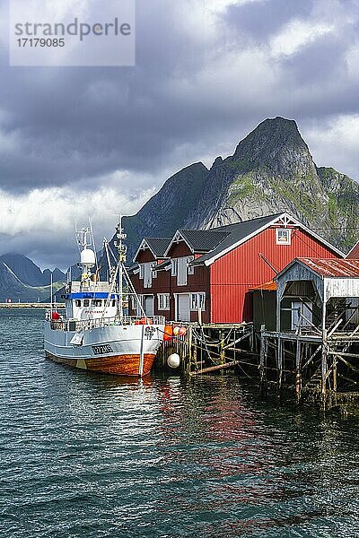 Rorbuer  typische Holzhäuser  Fischerboot im Hafen  Reine  Moskenesöy  Lofoten  Nordland  Norwegen  Europa