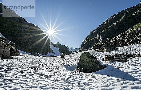 Junge Frau  Bergsteigerin im Schneefeld beim Aufstieg  Berge  Wanderung zur Trollfjord Hytta  am Trollfjord  Lofoten  Nordland  Norwegen  Europa
