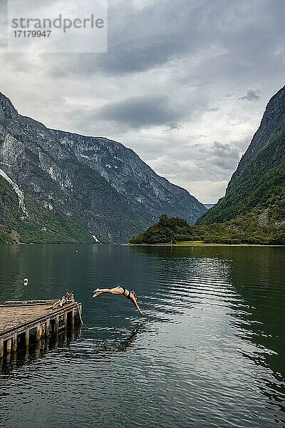Frau springt ins Wasser  Naeroyfjord  Aurland  Sogn og Fjordane  Norwegen  Europa