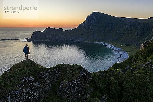 Abendstimmung  Wanderin auf Felsen  Klippen  Strand und Meer  hinten Gipfel des Berges Måtinden  bei Stave  Nordland  Norwegen  Europa