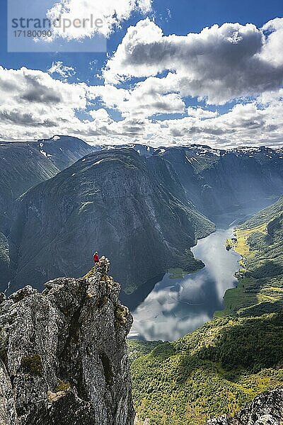 Wanderin steht auf Felszunge  Grat  Blick vom Gipfel des Breiskrednosi  Berge und Fjord  Nærøyfjord  Aurland  Norwegen  Europa