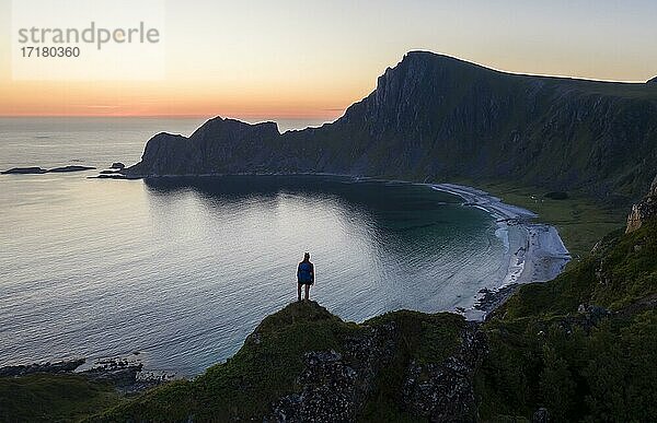 Abendstimmung  Wanderin auf Felsen  Klippen  Strand und Meer  hinten Gipfel des Berges Måtinden  bei Stave  Nordland  Norwegen  Europa