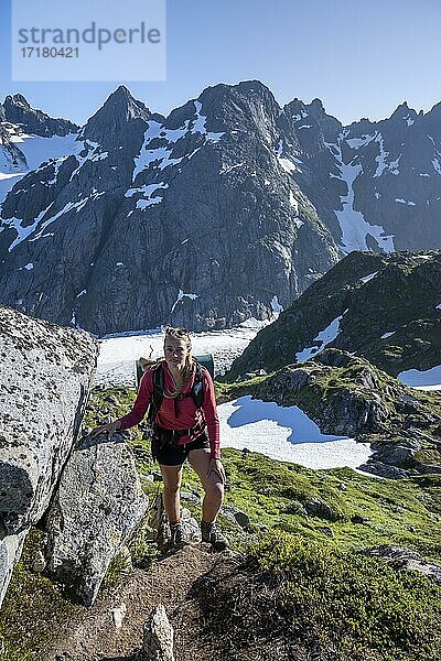 Junge Frau beim Wandern  Berge und Schnee  Wanderung zur Trollfjord Hytta  am Trollfjord  Lofoten  Nordland  Norwegen  Europa