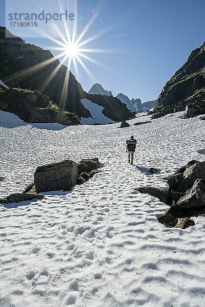 Junge Frau  Bergsteigerin im Schneefeld beim Aufstieg  Berge  Wanderung zur Trollfjord Hytta  am Trollfjord  Lofoten  Nordland  Norwegen  Europa
