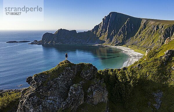 Wanderin steht am Abgrund  Klippen  Strand und Meer  hinten Gipfel des Berges Måtinden  bei Stave  Nordland  Norwegen  Europa