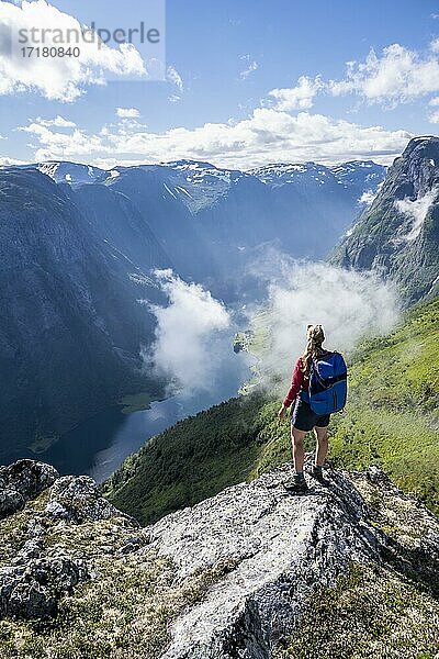 Wanderin blickt ins Tal  Blick vom Gipfel des Breiskrednosi  Berge und Fjord  Nærøyfjord  Aurland  Norwegen  Europa