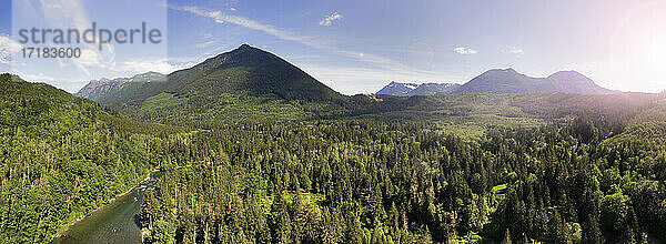 Bergkette und Wälder im Tal  erhabener Blick auf eine majestätische Landschaft und einen breiten Fluss.