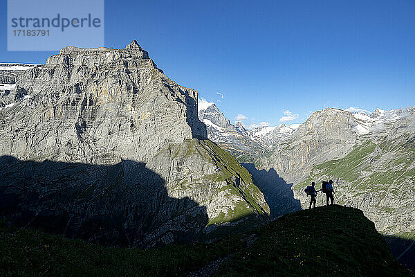 Zwei Wanderer bewundern die Berge während der Wanderung zur Muttsee-Hütte auf dem Kalktrittli-Weg  Kanton Glarus  Schweiz  Europa