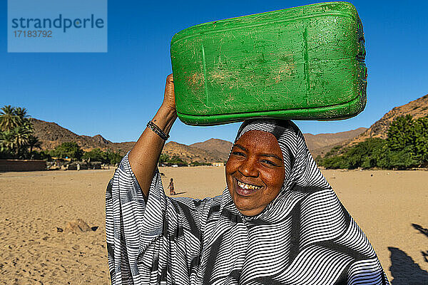 Frau trägt einen Wasserbehälter auf dem Kopf  Oase von Timia  Air Mountains  Niger  Afrika