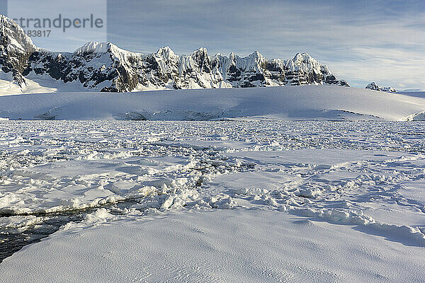 Schneebedeckte Berge und dichtes Meereis im Neumayer-Kanal  Palmer-Archipel  Antarktis  Polarregionen