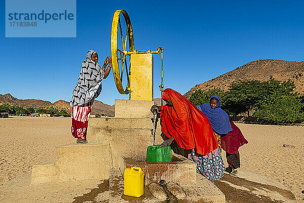 Einheimische Frauen drehen das Rad an einem Wasserbrunnen  Oase von Timia  Air Mountains  Niger  Afrika