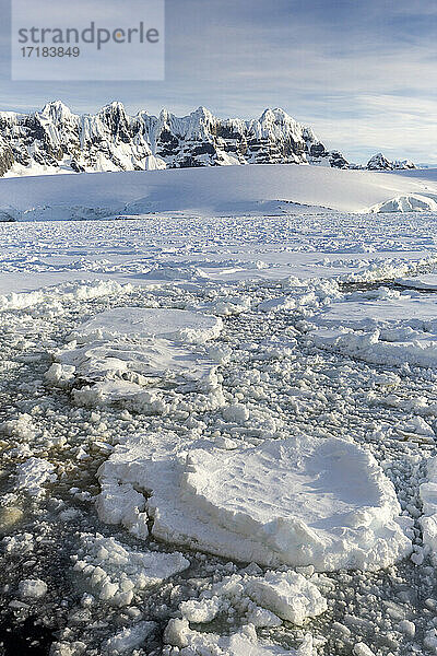 Schneebedeckte Berge und dichtes Meereis im Neumayer-Kanal  Palmer-Archipel  Antarktis  Polarregionen