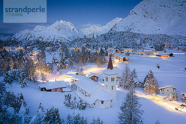 Dämmerung über Chiesa Bianca und Maloja Dorf mit Schnee bedeckt  Bergell  Engadin  Kanton Graubünden  Schweiz  Europa