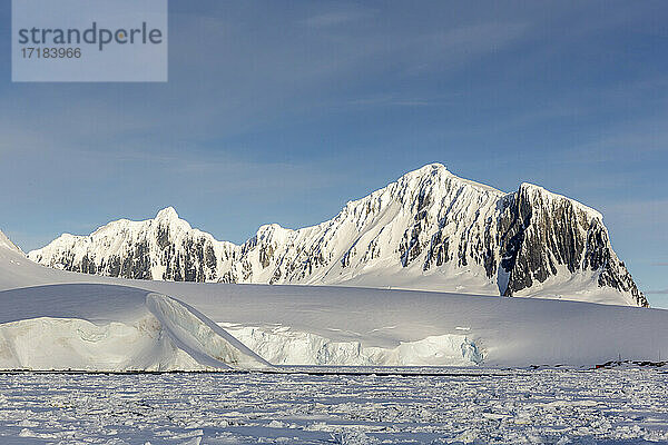 Schneebedeckte Berge und dichtes Meereis im Neumayer-Kanal  Palmer-Archipel  Antarktis  Polarregionen