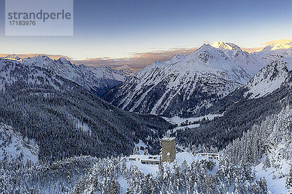 Sonnenaufgang auf alten Turm Torre Del Belvedere und verschneite Wälder  Maloja  Bergell  Engadin  Kanton Graubünden  Schweiz  Europa