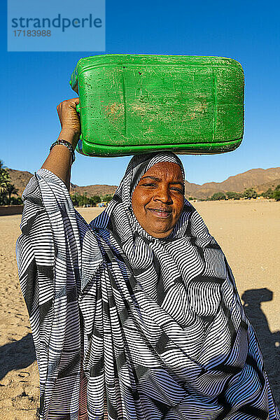 Frau trägt einen Wasserbehälter auf dem Kopf  Oase von Timia  Air Mountains  Niger  Afrika