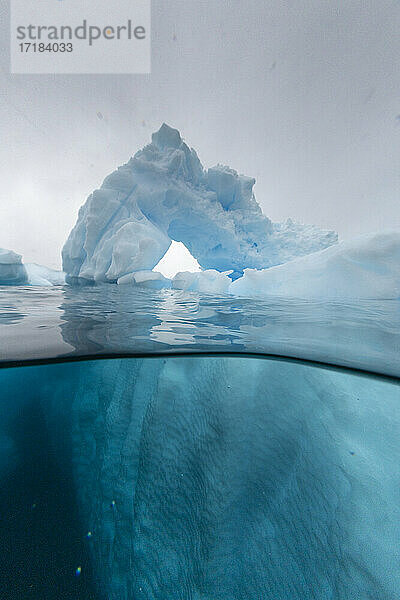 Ober- und Untersicht eines in einem Eisberg geformten Bogens bei Cuverville Island  Ererra-Kanal  Antarktis  Polarregionen