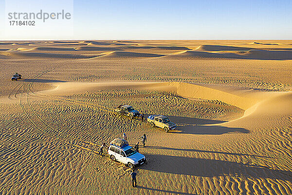 Luftaufnahmen von Autos  die durch die Sanddünen der Tenere-Wüste fahren  Sahara  Niger  Afrika