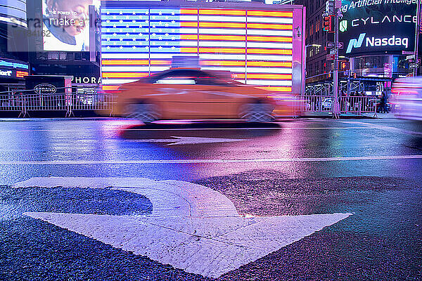 Taxi verwischt durch eine beleuchtete Flagge der Vereinigten Staaten von Amerika am Times Square  New York City  Vereinigte Staaten von Amerika  Nordamerika