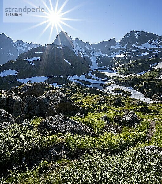 Wanderweg  Sonne scheint auf Berge mit Schnee  Bergkette an der Trollfjord Hytta  am Trollfjord  Lofoten  Nordland  Norwegen  Europa