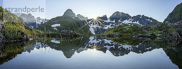 Bergpanorama  Hochmoor  Berge spiegeln sich in einem Teich  Sonne scheint über Berge mit Schnee  an der Trollfjord Hytta  am Trollfjord  Lofoten  Nordland  Norwegen  Europa