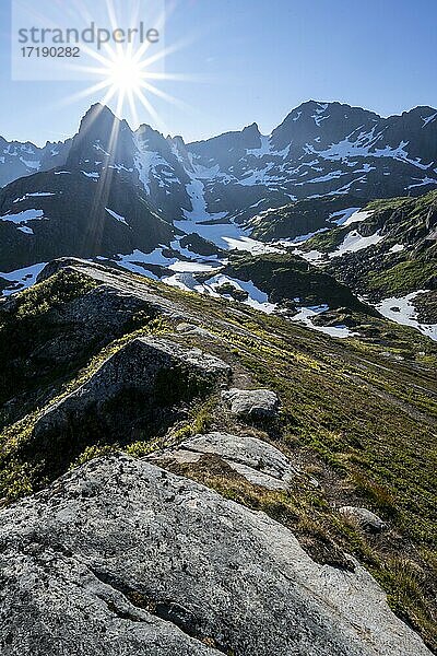 Wanderweg  Sonne scheint auf Berge mit Schnee  Bergkette an der Trollfjord Hytta  am Trollfjord  Lofoten  Nordland  Norwegen  Europa