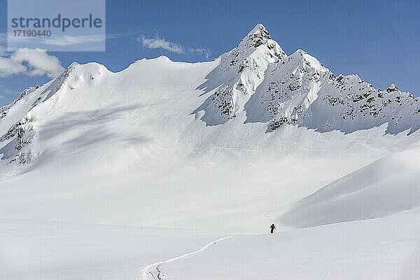 Mittlere Fernsicht einer Person auf einem schneebedeckten Berg im Urlaub