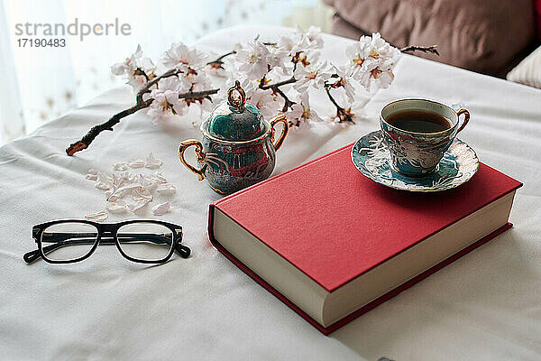 Stilleben mit einem Buch  Kaffeetassen und Mandelblüten. Konzept Lesen
