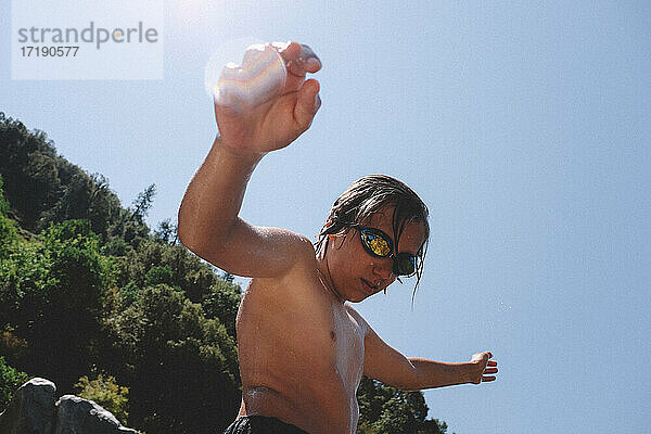 Tween Boy in Goggles Dripping Wasser auf einem Mid Summer Day