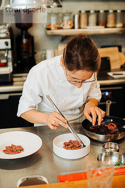 Michelin-Koch serviert Essen auf einem Teller  während er im Restaurant arbeitet