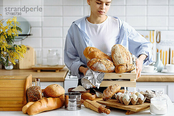junges Mädchen mit Brot in der Hand in der Küche