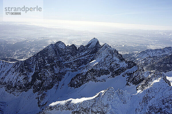 Drohnenansicht einer verschneiten Bergkette an einem sonnigen Tag