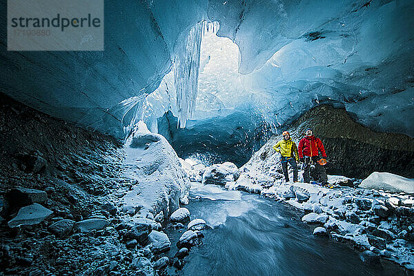 Männer erforschen Eishöhle in Thórsmörk - Island