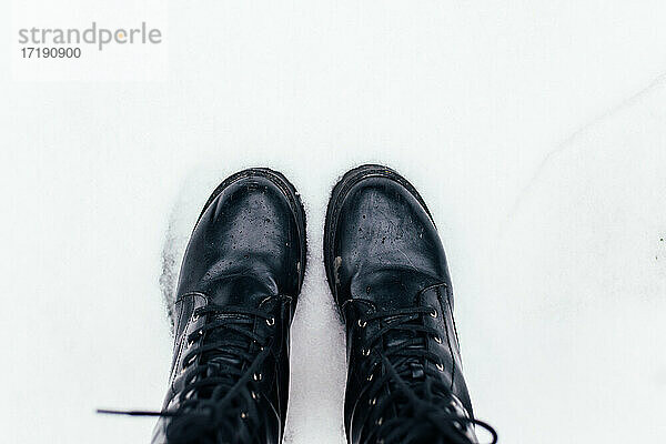 Schwarze Stiefel im Schnee