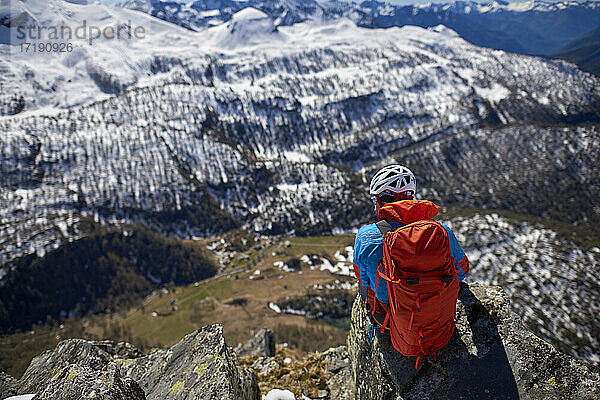 Ein Mann besteigt an einem sonnigen Tag einen verschneiten Berg in Devero  Italien.