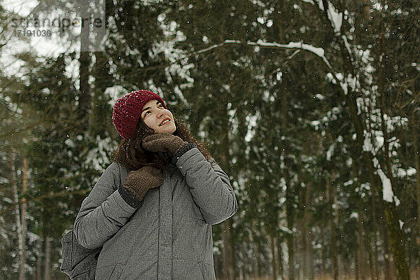Ein Mädchen mit rotem Hut lächelt  schaut in den Himmel  lächelt  es schneit.