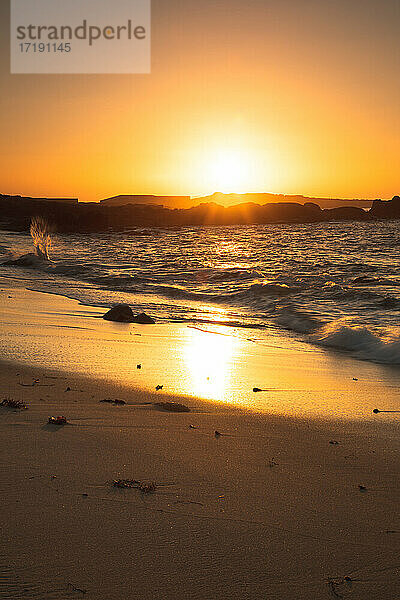 Sonnenuntergang an einem Strand mit Felsformationen