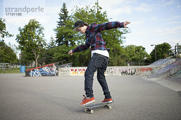 Skateboarder landet Trick beim Skateboardfahren im Skatepark