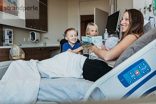 Geschwister treffen ihren neugeborenen Bruder im Krankenhaus zum ersten Mal
