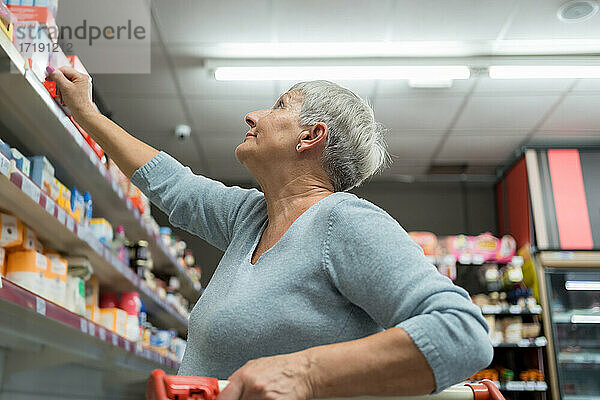 Kaukasische ältere erwachsene Frau beim Einkaufen in einem Supermarkt