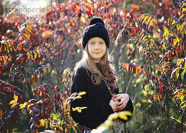 Schönes junges Mädchen in schwarzem Pullover und Hut im Freien im Herbst.