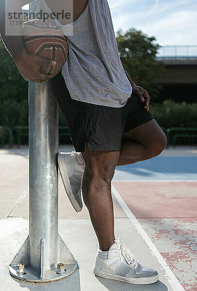 Ausgeschnittener ethnischer Sportler  der sich auf dem Basketballplatz ausruht