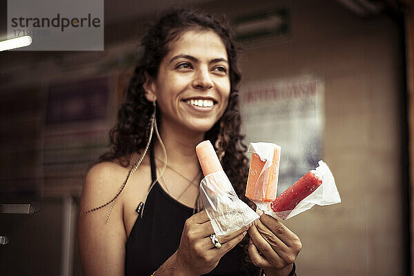 Attraktive lächelnde junge alternative mexikanische Frau mit Eiscreme
